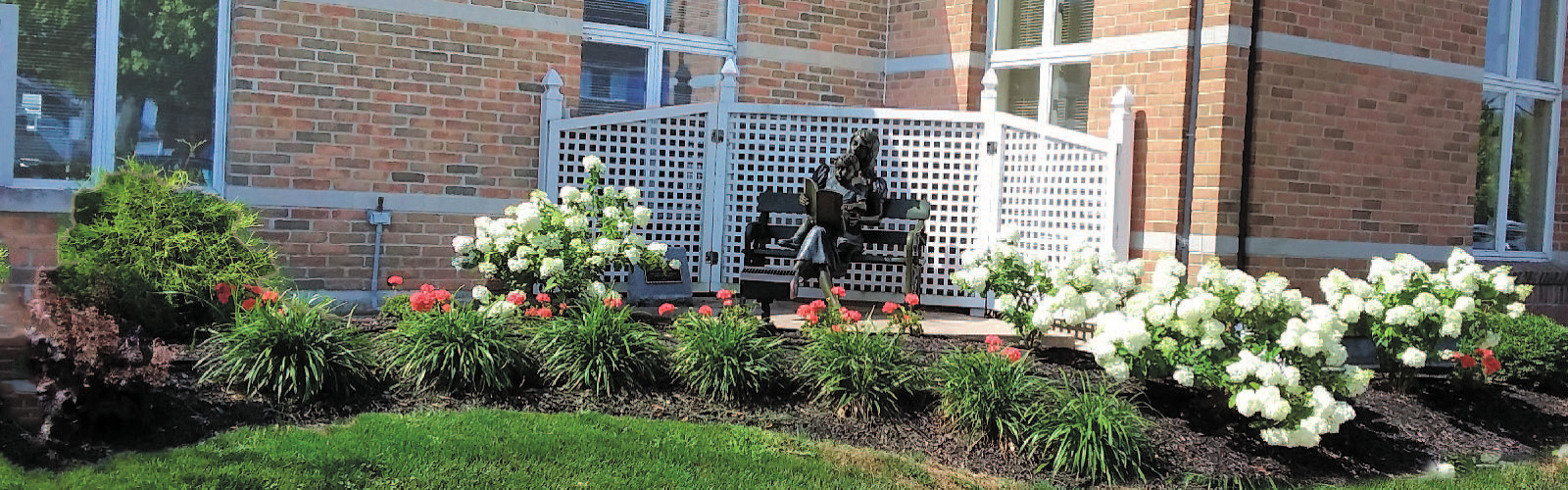 Library garden with a statue sitting on a bench