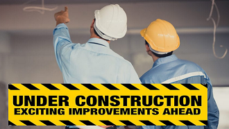 2 men looking at ceiling with Under Construction sign in foreground